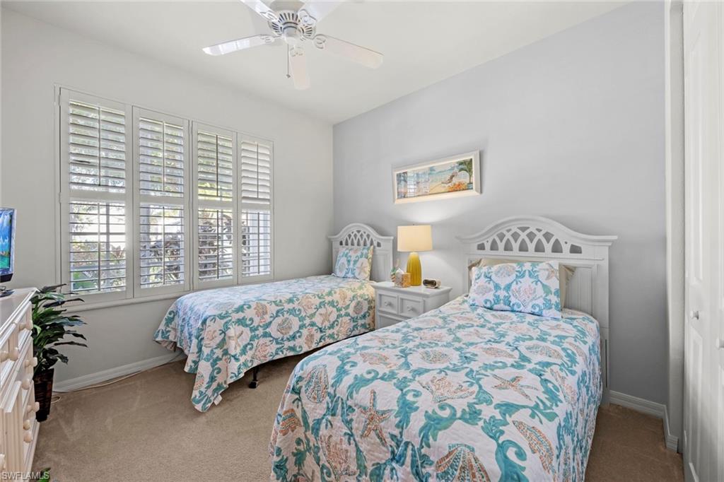 9006 Whitfield Drive Estero, FL 33928 - Photo 22 of 43 a bedroom with two beds and a chandelier