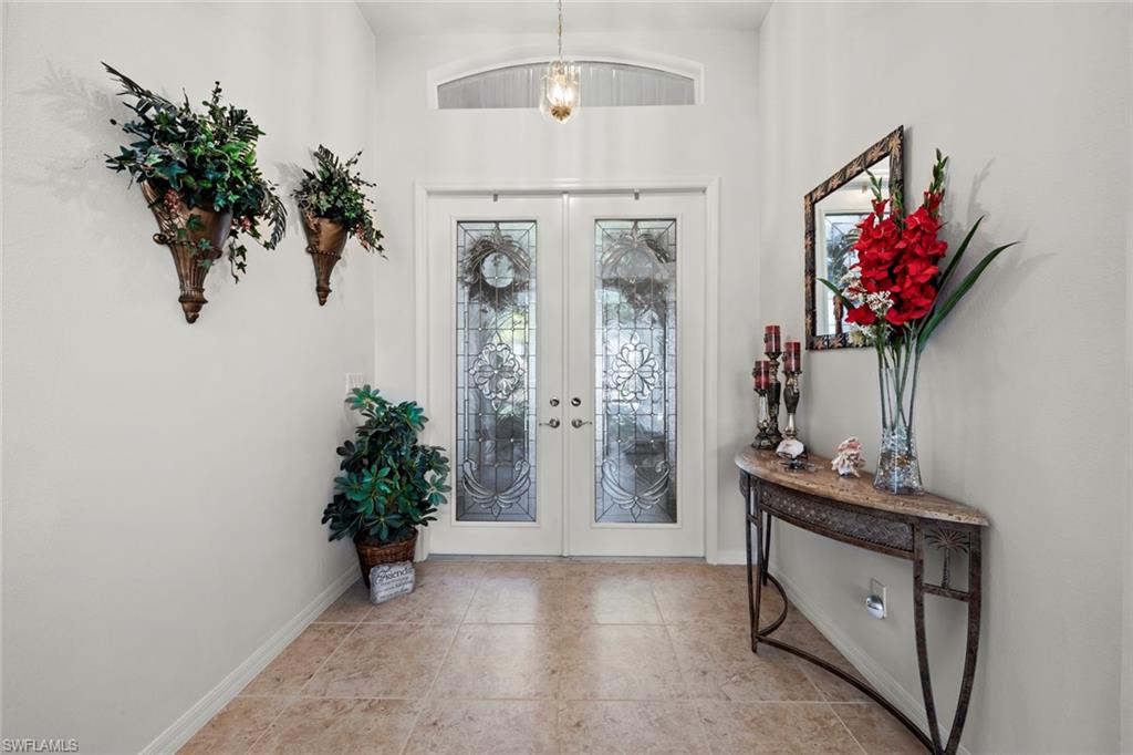 9006 Whitfield Drive Estero, FL 33928 - Photo 4 of 43 an entryway with a flower pot and a bookshelf