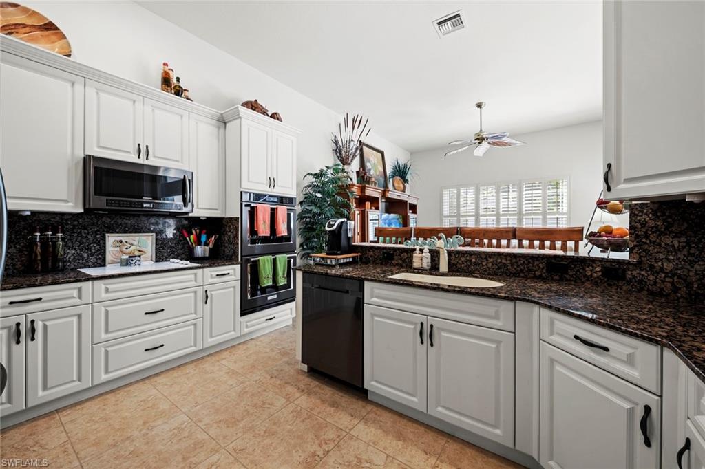 9006 Whitfield Drive Estero, FL 33928 - Photo 9 of 43 a kitchen with stainless steel appliances granite countertop a sink and cabinets
