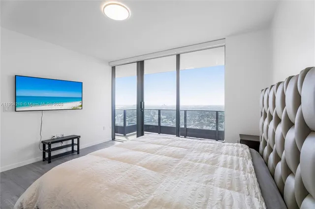 a bedroom with a large bed and a night stand