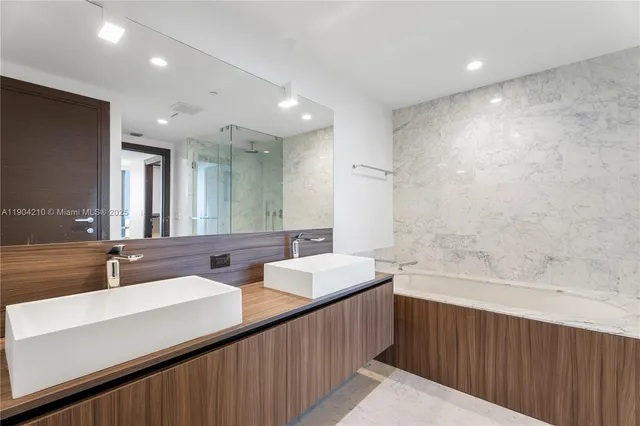 a bathroom with a double vanity sink mirror and shower