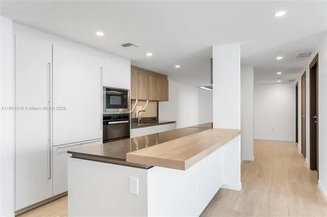 a kitchen with stainless steel appliances granite countertop a sink a stove and a refrigerator