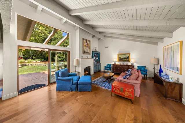 a living room with furniture fireplace and a large window
