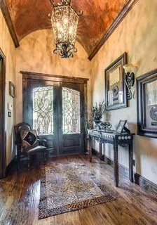 a living room with furniture a fireplace and large windows