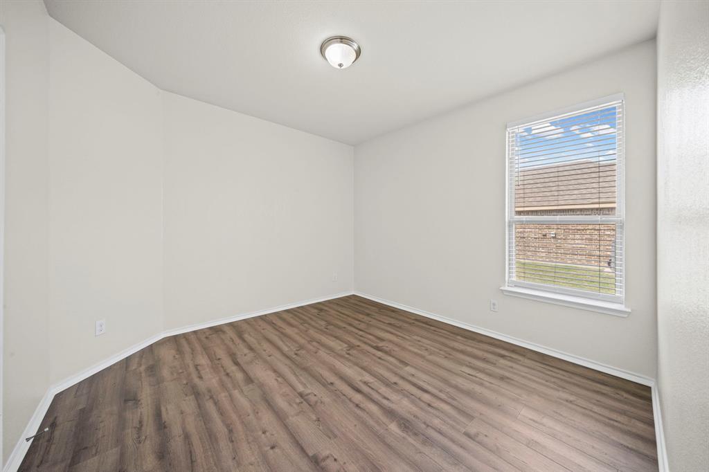 1205 Crest Ridge Drive Glenn Heights, TX 75154 - Photo 16 of 26 an empty room with wooden floor and windows