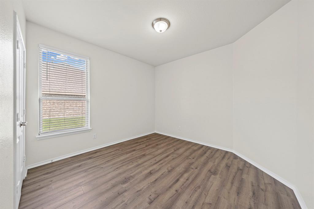 1205 Crest Ridge Drive Glenn Heights, TX 75154 - Photo 19 of 26 an empty room with wooden floor and windows