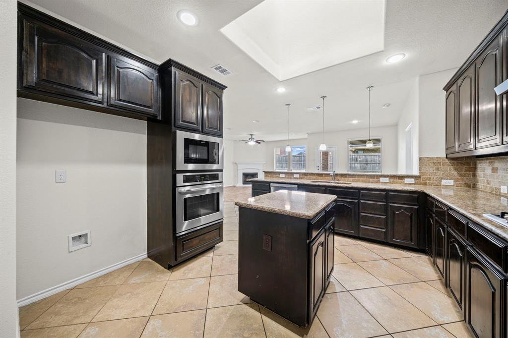 1205 Crest Ridge Drive Glenn Heights, TX 75154 - Photo 5 of 26 a kitchen with stainless steel appliances granite countertop a stove and a refrigerator