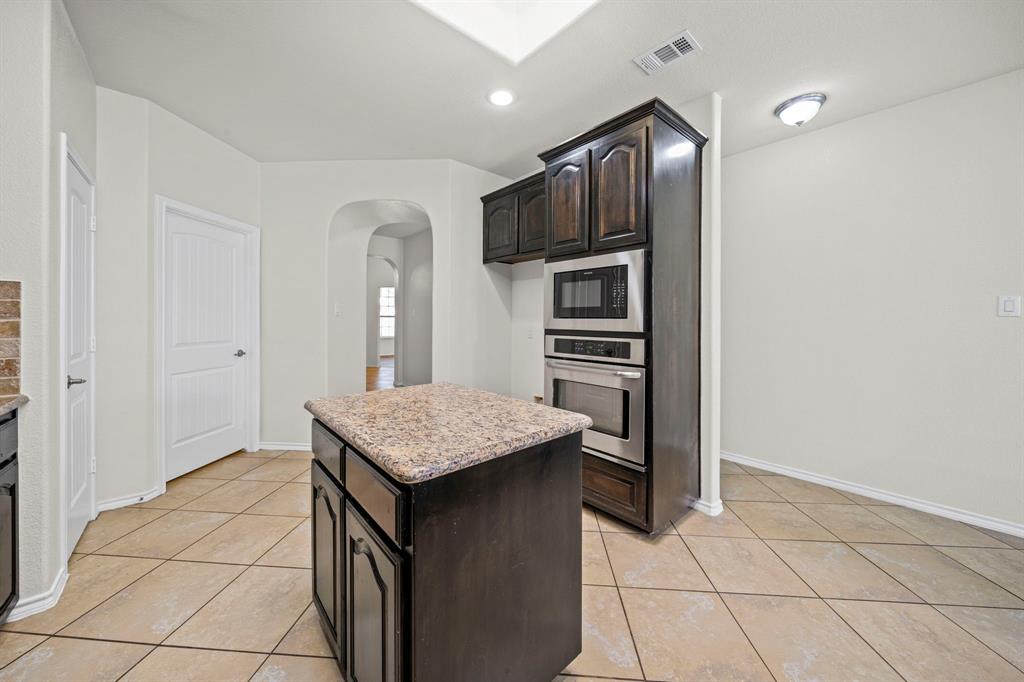 1205 Crest Ridge Drive Glenn Heights, TX 75154 - Photo 7 of 26 a kitchen with stainless steel appliances granite countertop a refrigerator and a stove top oven