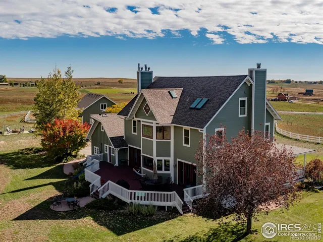 an aerial view of a house with swimming pool and outdoor seating