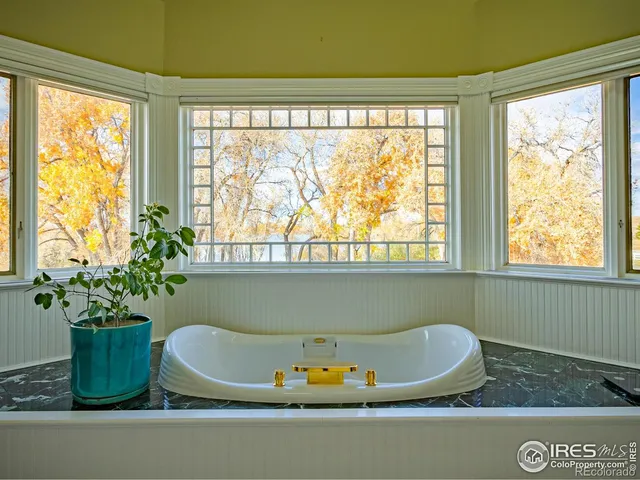 a view of swimming pool with outdoor seating and trees in the background
