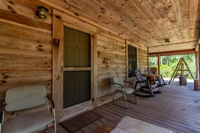 a view of a balcony with chairs and wooden floor