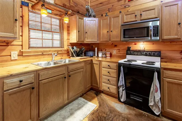 a kitchen with stainless steel appliances a stove sink and microwave