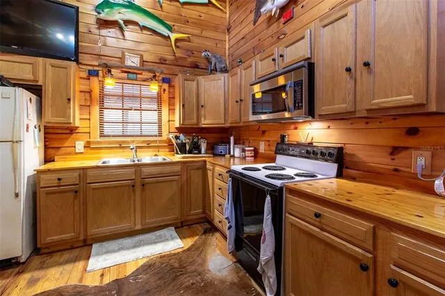 a kitchen with stainless steel appliances granite countertop a sink a stove and a microwave