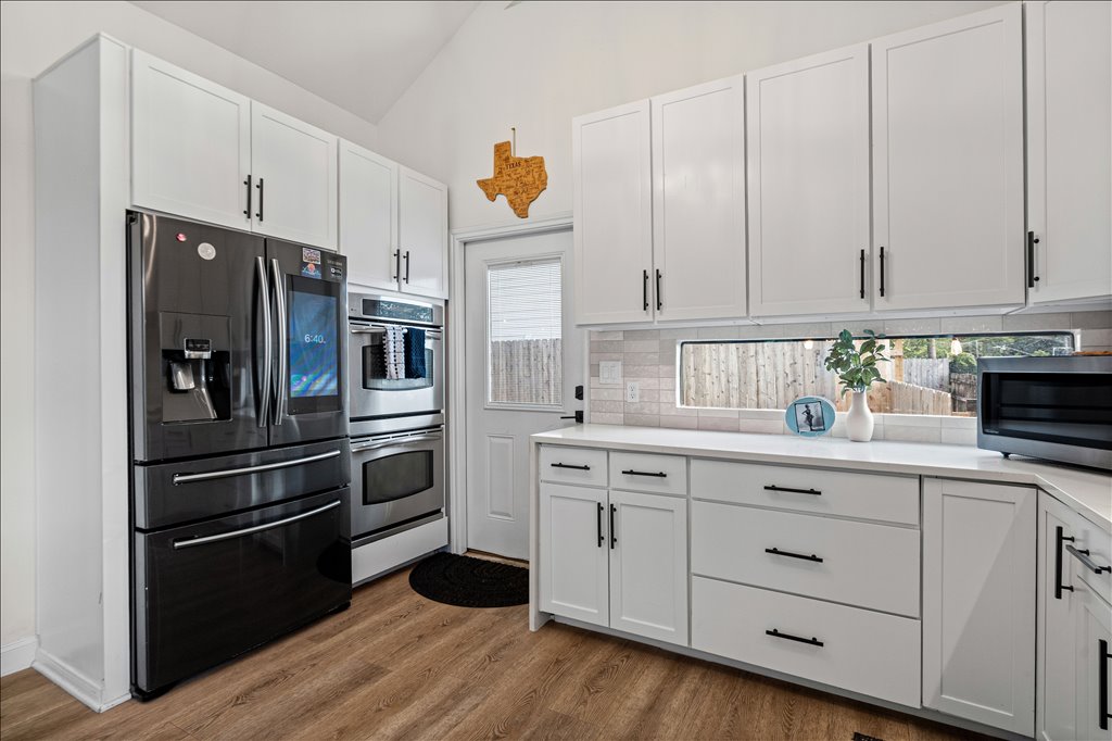 1201 Garden Street, Unit A Austin, TX 78702 - Photo 12 of 30 Modern kitchen with sleek white cabinetry and integrated appliances provides a clean aesthetic.