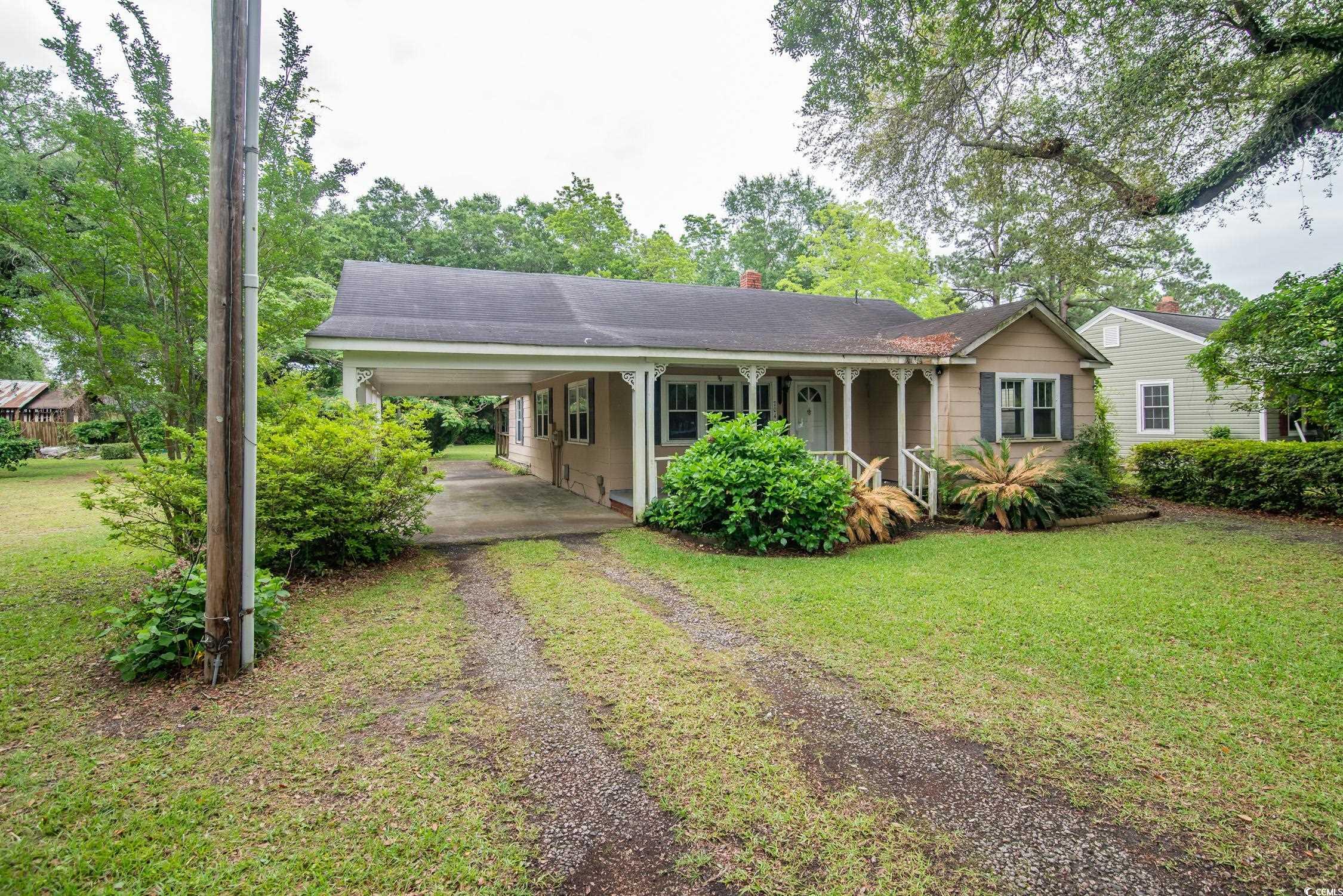704 North Congdon Street Georgetown, SC 29440 - Photo 1 of 35 Ranch-style home with driveway, an attached carport, covered porch, and a front yard