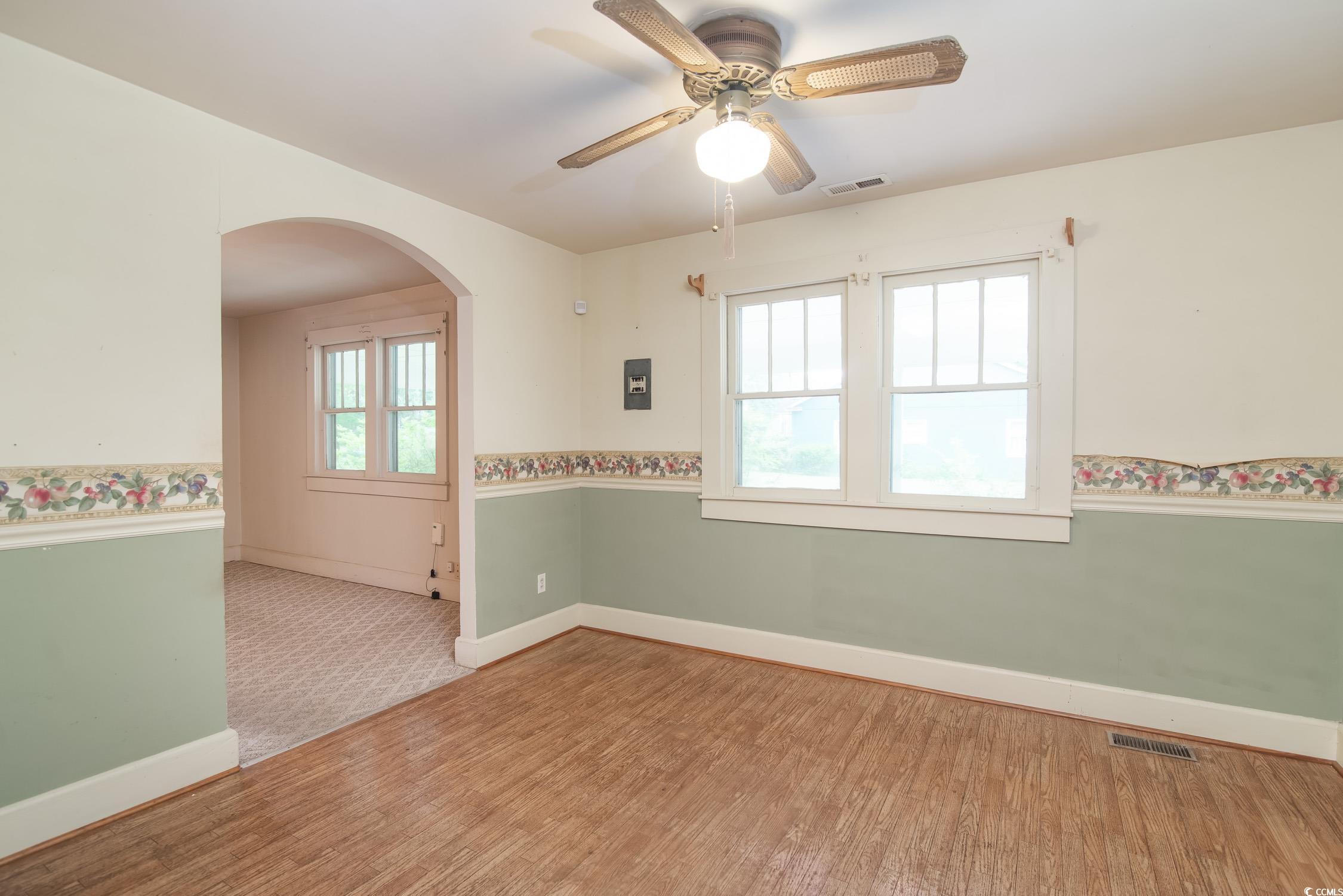 704 North Congdon Street Georgetown, SC 29440 - Photo 13 of 35 Spare room featuring arched walkways, wood finished floors, baseboards, and ceiling fan