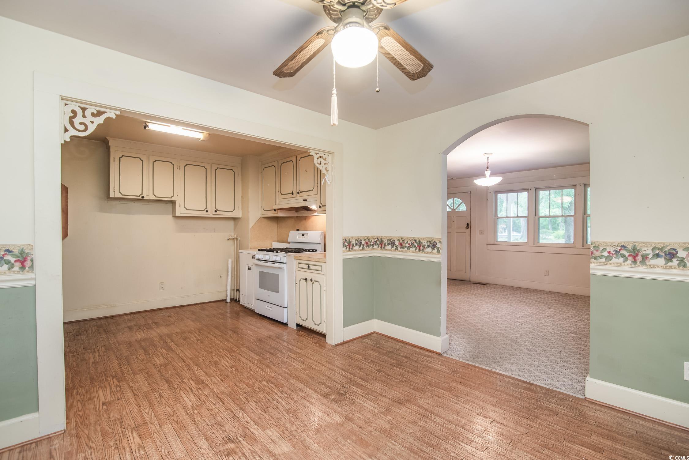 704 North Congdon Street Georgetown, SC 29440 - Photo 14 of 35 Kitchen featuring white range with gas cooktop, arched walkways, a ceiling fan, and light wood-style flooring
