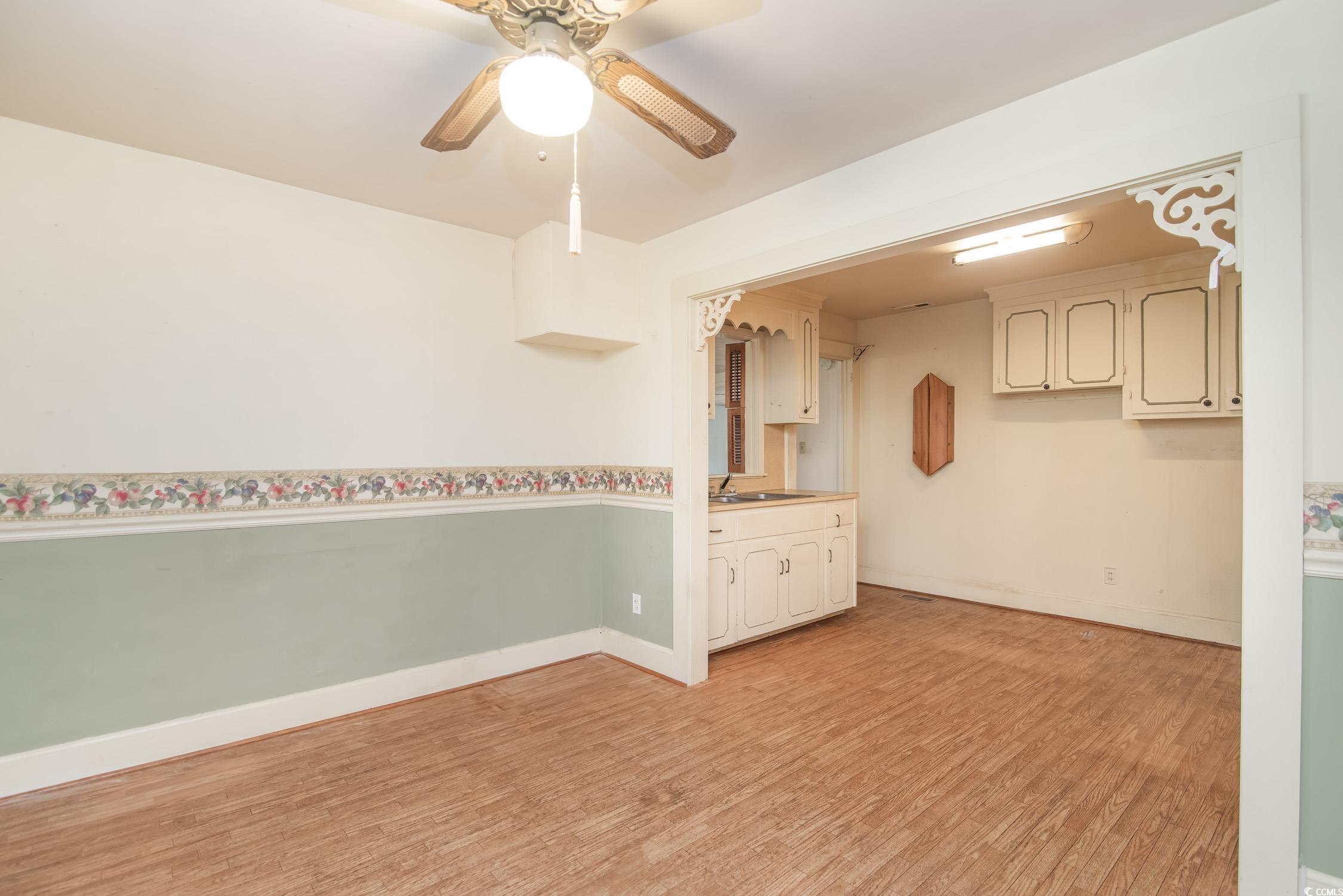704 North Congdon Street Georgetown, SC 29440 - Photo 15 of 35 Unfurnished room with light wood finished floors, ceiling fan, a sink, and baseboards