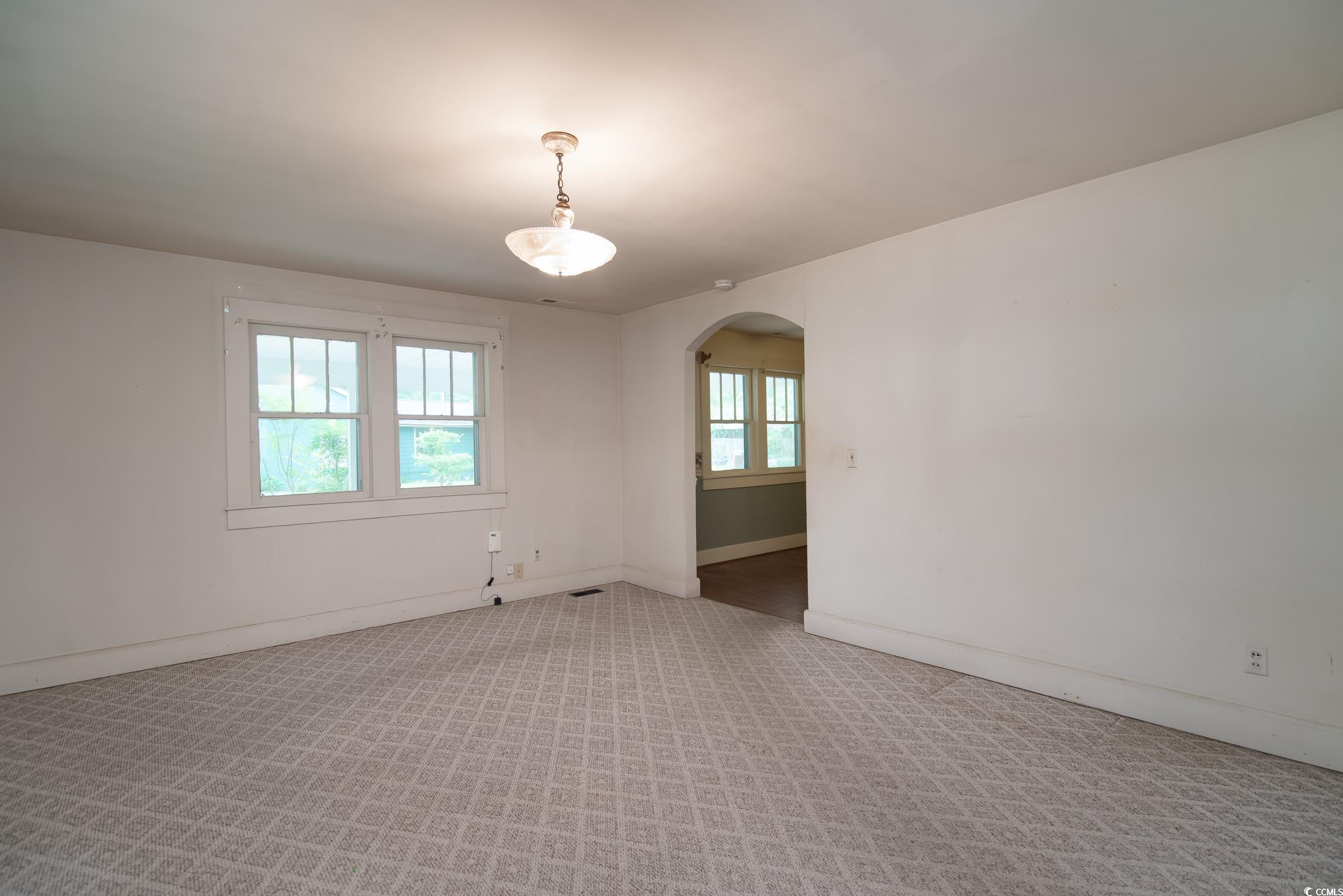 704 North Congdon Street Georgetown, SC 29440 - Photo 18 of 35 Unfurnished room featuring arched walkways, light carpet, and baseboards