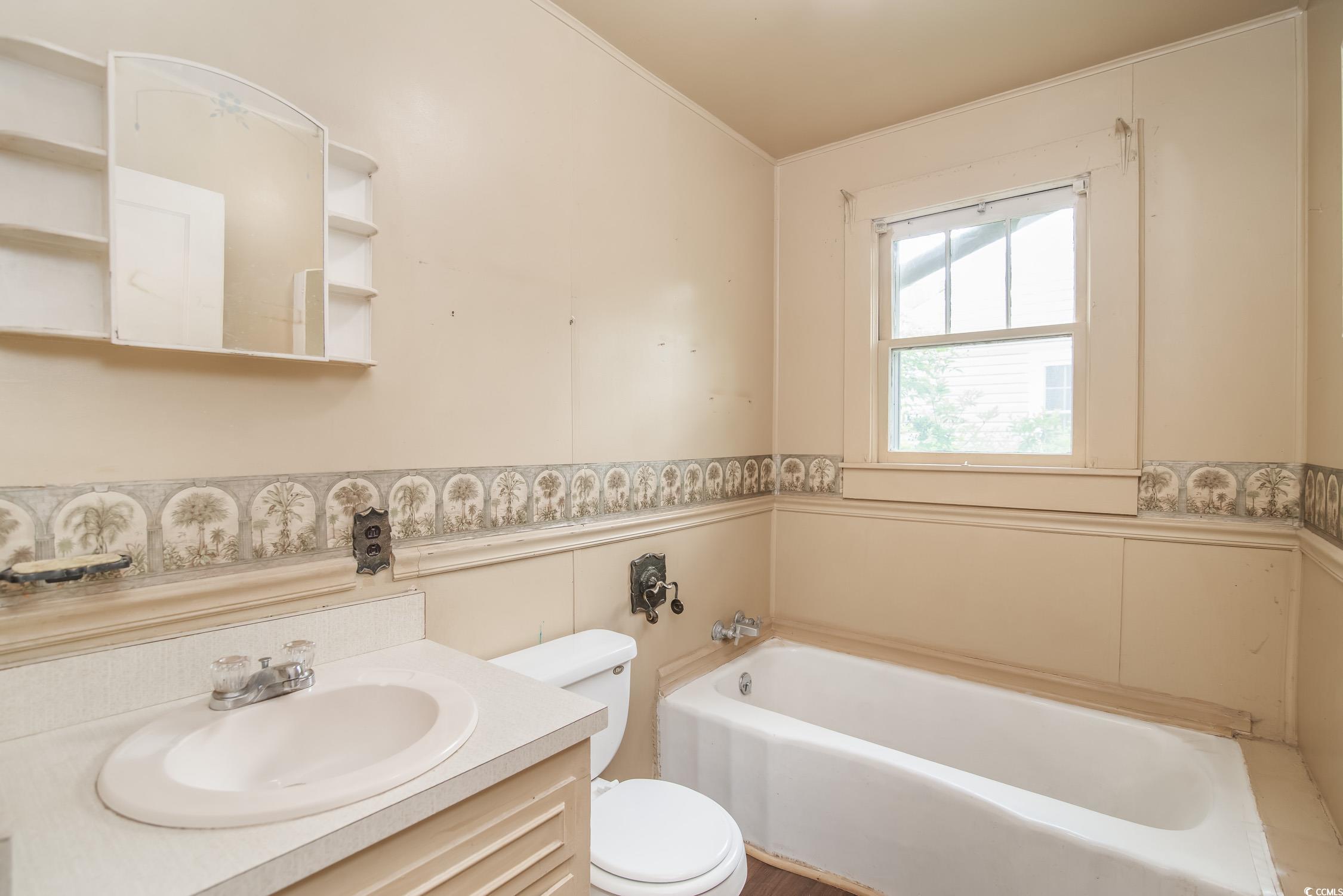 704 North Congdon Street Georgetown, SC 29440 - Photo 21 of 35 Full bathroom with toilet, a bath, vanity, and wainscoting
