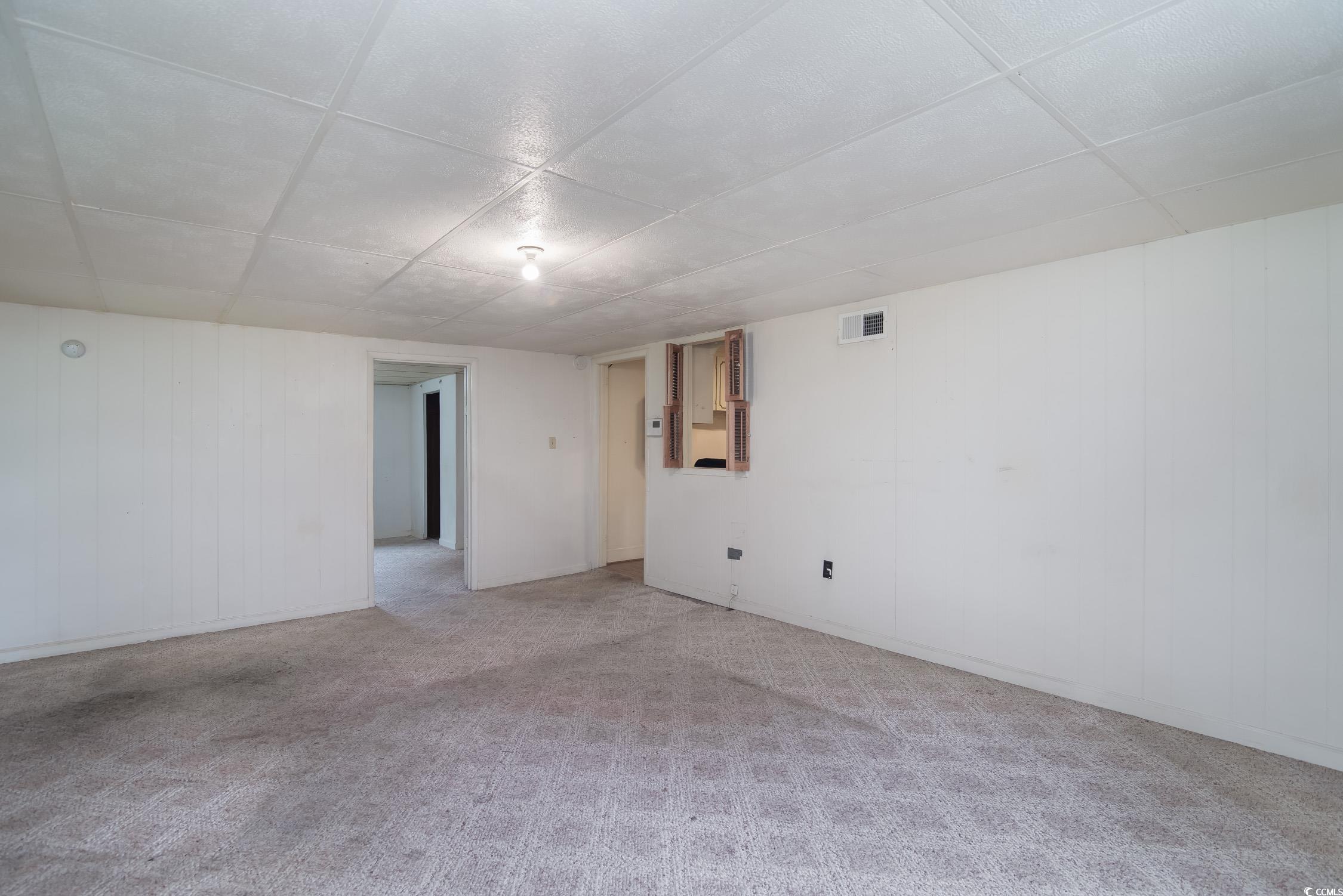 704 North Congdon Street Georgetown, SC 29440 - Photo 29 of 35 Spare room featuring a paneled ceiling and light carpet