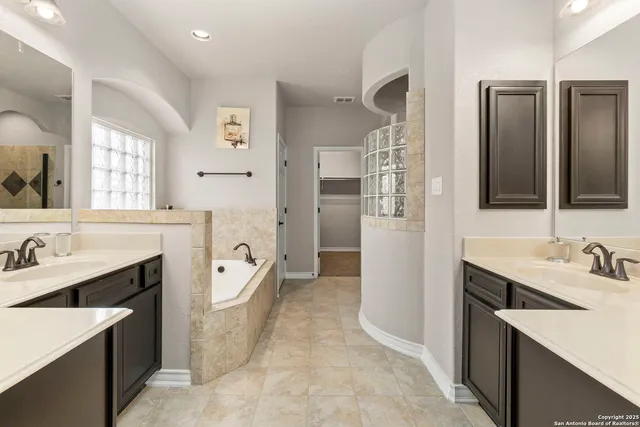 a spacious bathroom with a bathtub sink and mirror