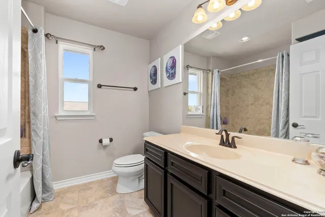 a bathroom with a sink a toilet a mirror and shower