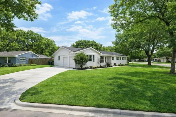 a front view of a house with a yard and trees