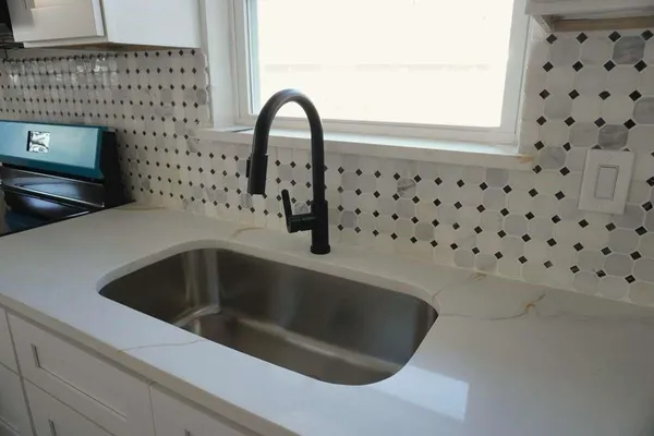 a kitchen with stainless steel appliances a stove microwave and sink