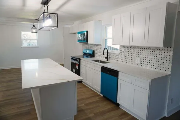 a kitchen with stainless steel appliances granite countertop a sink a stove and a refrigerator