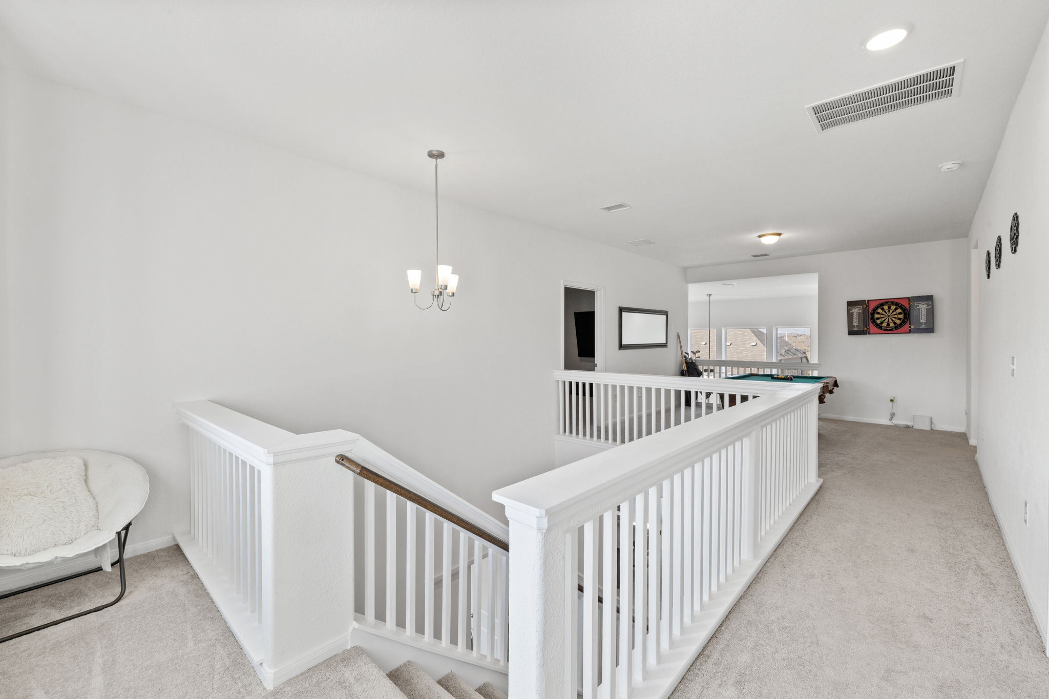189 Durian Loop Buda, TX 78610 - Photo 18 of 38 Hallway with light colored carpet, a chandelier, and an upstairs landing