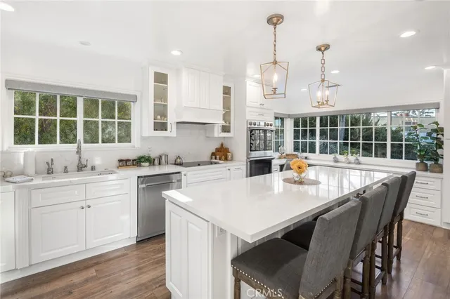 a kitchen with a dining table chairs and white cabinets
