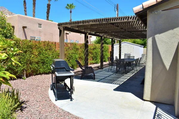 a view of a patio with a table chairs and a potted plant