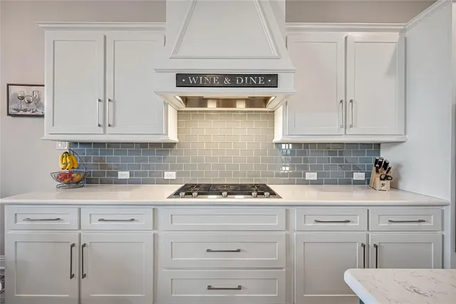 a kitchen with white cabinets and appliances