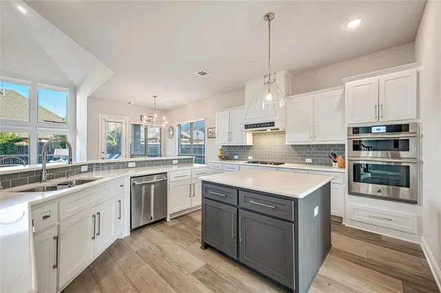 a kitchen with stainless steel appliances granite countertop a stove sink and cabinets