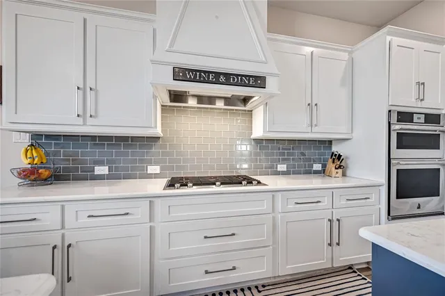 a kitchen with cabinets appliances a sink and a counter top space