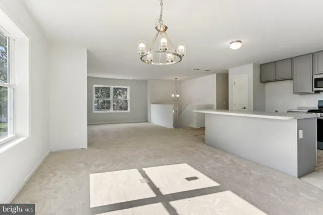 a view of a kitchen with a sink hardwood floor and a living room