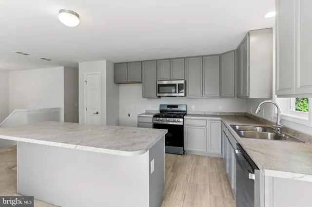 a kitchen with granite countertop a sink stove and refrigerator