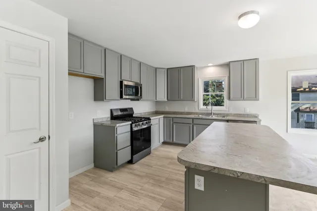 a kitchen with granite countertop stainless steel appliances and white cabinets