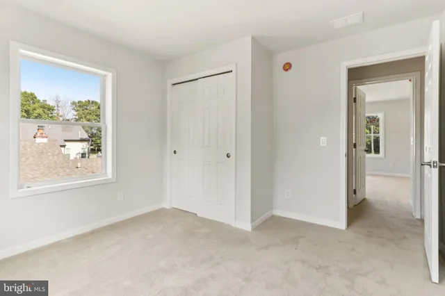 a view of an empty room with a fireplace and a window