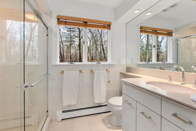 a bathroom with a granite countertop sink toilet and shower