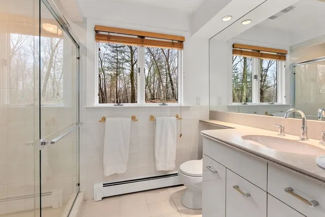a bathroom with a granite countertop sink toilet and shower