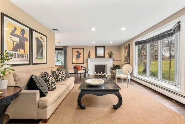 a living room with furniture a large window and a fireplace