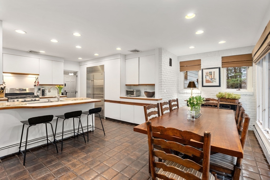 21 Gail Road Weston, MA 02493 - Photo 5 of 19 a kitchen with a table chairs microwave and cabinets
