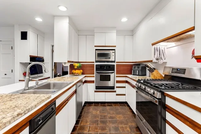 a kitchen with stainless steel appliances a stove a sink and a refrigerator