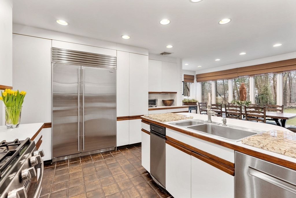 21 Gail Road Weston, MA 02493 - Photo 8 of 19 a kitchen with stainless steel appliances granite countertop a sink and a refrigerator