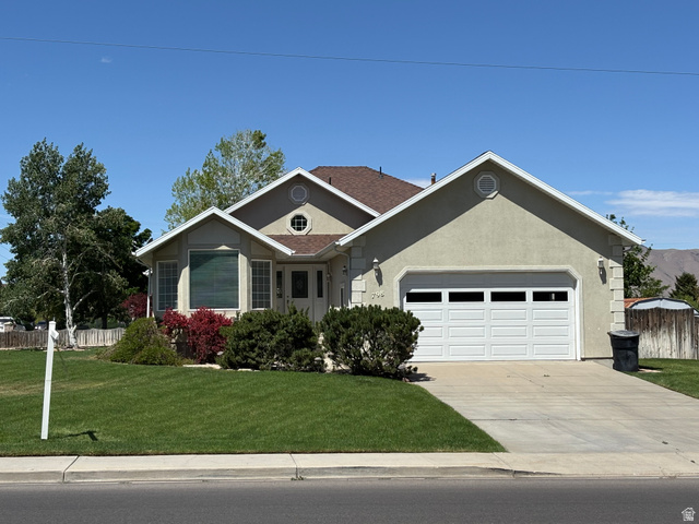 Single-story residence featuring stucco exterior and a two-car garage with panel windows