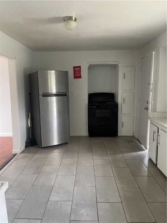 307 West 3rd Street Alice, TX 78332 - Photo 5 of 7 a view of a refrigerator in kitchen and an empty room