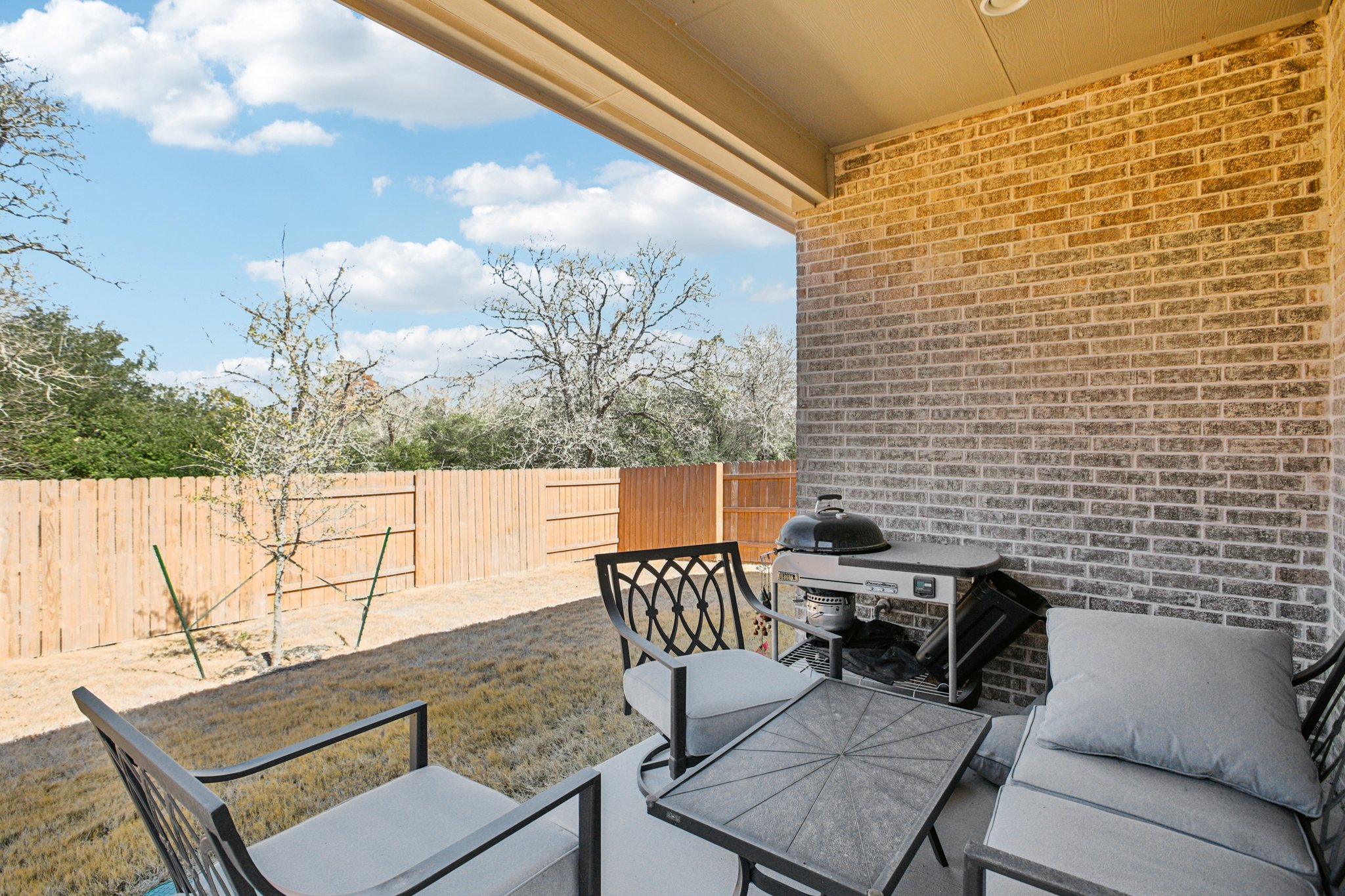 149 Plumbago Loop Bastrop, TX 78602 - Photo 4 of 33 Fenced backyard featuring an outdoor hangout area, a patio area, and grilling area
