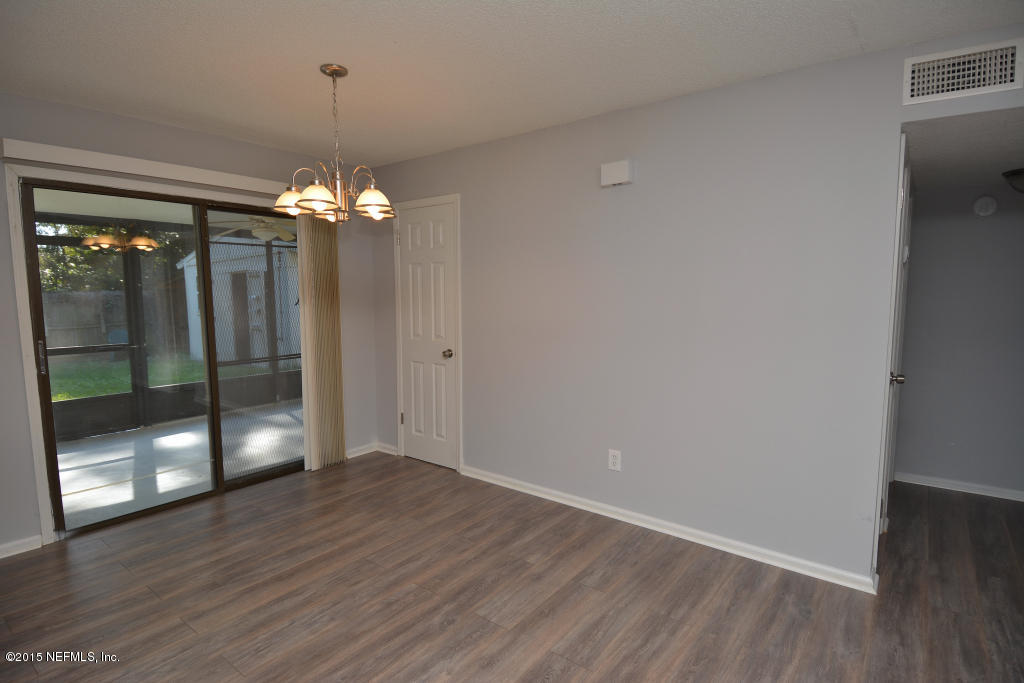 3156 Ricky Drive Jacksonville, FL 32223 - Photo 4 of 9 wooden floor in an empty room with a window